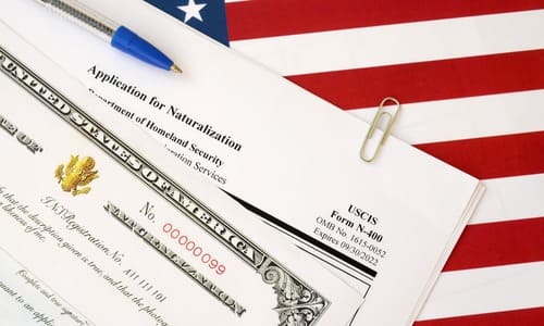A copy of the Form N-400 visa application on a table with an American flag print.