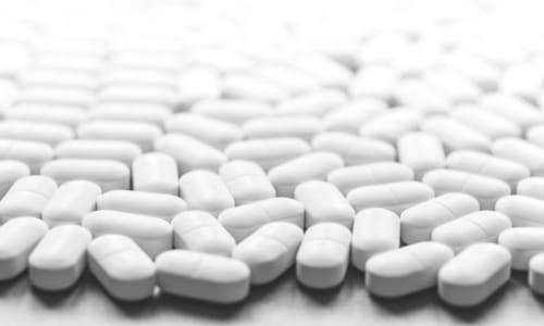 White tablets against a white background laid out on a table.