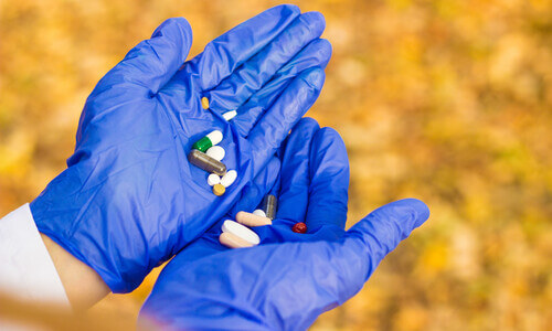 Doctor holding pills and tablets in cupped hands.