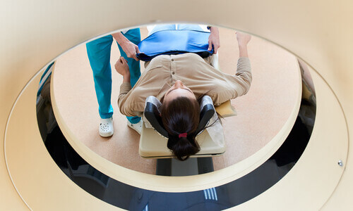 Female patient lying down about to enter an mri machine.