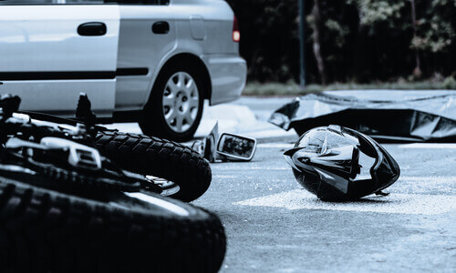 Black helmet on the ground after an accidental collision between a motorcycle and a car.