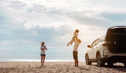 A happy family on a summer road trip to the beach in California.