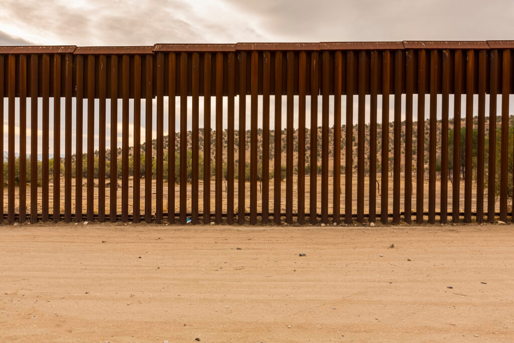 A view of the Sonoran desert as seen through the rails of the US-Mexico border fence.