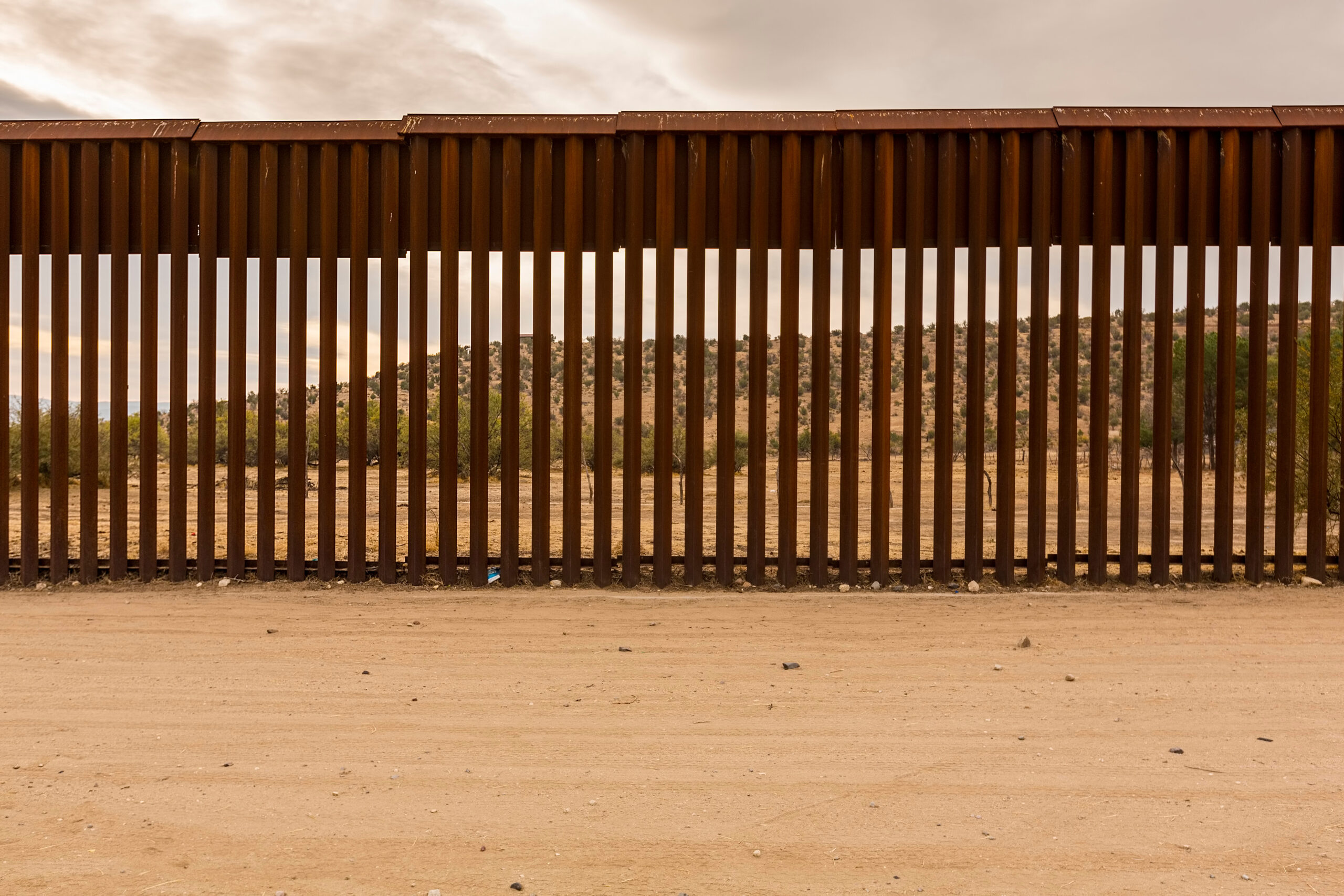 A view of the Sonoran desert as seen through the rails of the US-Mexico border fence.