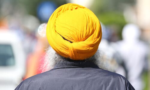 A rear-view shot of an elderly Sikh having finally arrived in the US.