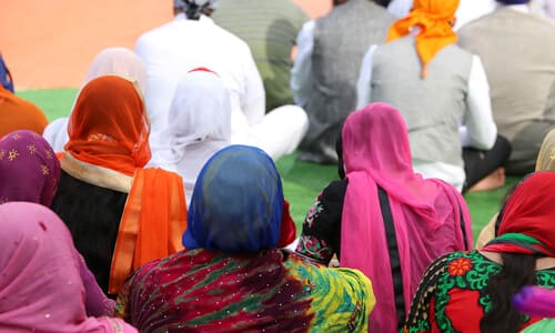 Indian refugees waiting for transport while sitting in the hot desert sun.