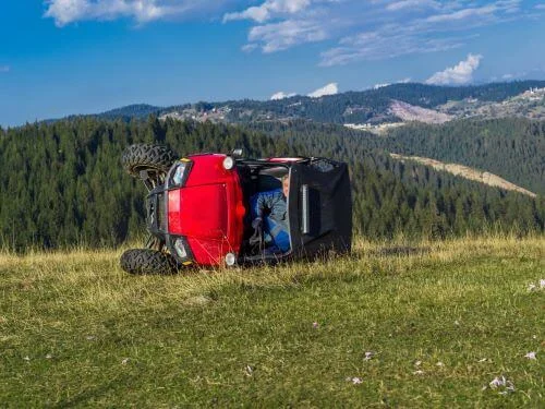 Red ATV on its side after an accident.