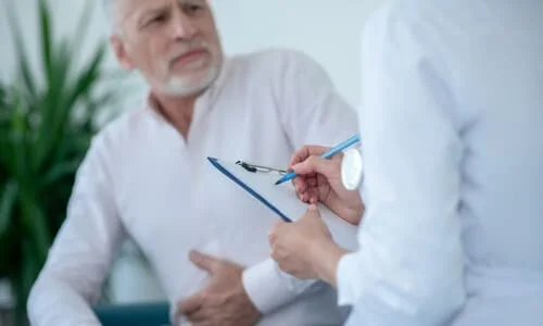 An elderly man consulting a doctor about some pain in his abdomen after an accident.