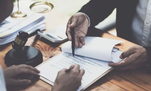 A lawyer at his desk helping a client out with her personal injury insurance claim.