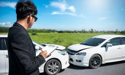 An insurance adjuster investigating the scene of an accident on a sunny afternoon.