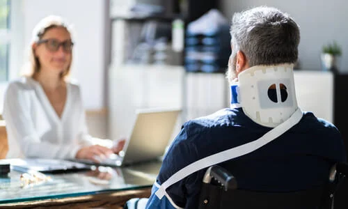 A client in a neck brace with his back turned to the camera