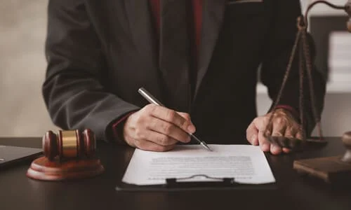 A lawyer at a desk working on documents for a personal injury lawsuit.