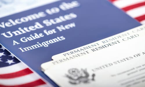 A closeup of a social security and green card with on top of a US flag.