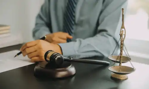A personal injury attorney in a grey shirt underlining points on a copy of a client's insurance policy.
