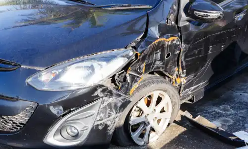 The right side of a dark colored vehicle totaled in an accident.