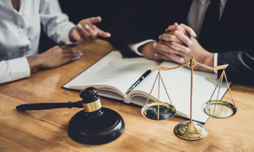 A lawyer listening intently at a client discussing details of his case.
