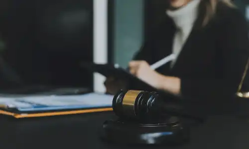A gavel lying in the foreground on the desk of a personal injury lawyer.