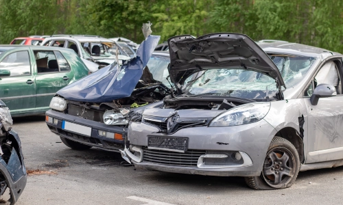 Two automobile wrecks in a scrap yard after a daytime car accident.
