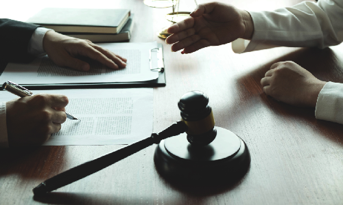 An L1 visa lawyer taking notes as a client explains their situation to them.