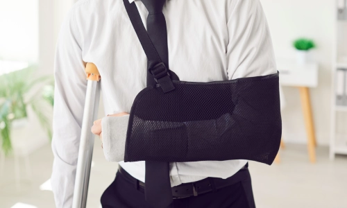 Person with a broken arm and crutches seeking help from an East Niles personal injury lawyer.