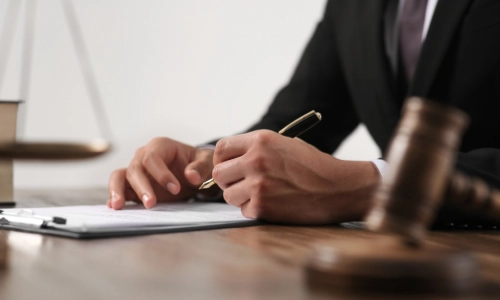 An Easton personal injury lawyer holding a pen and writing notes on a clipboard.