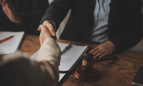 A man shaking hands with a San Antonio premises liability lawyer as a gesture of agreement and a good start of a client-lawyer partnership.