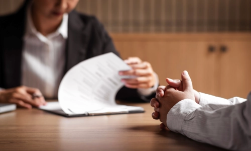 A female ATV Accident Lawyer reviewing case files with a client at a San Antonio law office.