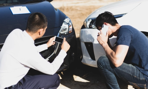 A San Antonio car accident lawyer inspecting his client’s damaged vehicle after the accident and taking photos to secure crucial evidence.