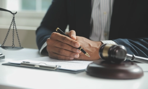 Close up of a Dog Bite Lawyer in a San Antonio office holding a pen on top of some files.
