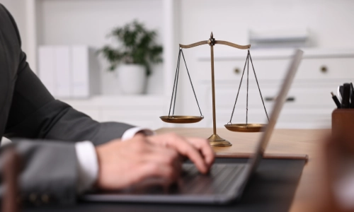 A East Sonora Personal Injury Lawyer typing on a gray laptop on an office table