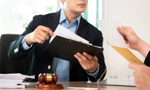 An Escalon Personal Injury Lawyer showing documents to a colleague in the office while sitting opposite to each other.