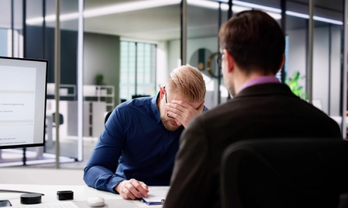A Modesto personal injury lawyer offering legal advice to his frustrated client during a consultation.
