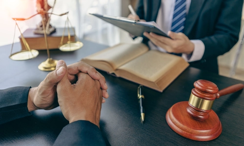 A Close up shot of a client's hands as they are talking to a Planada Personal Injury Lawyer who is holding a clipboard with case files