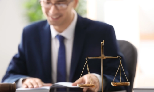 A Salida Personal Injury Lawyer reading a book while sitting at his table and smiling in his office