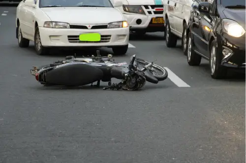 Motorcycle accident scene on a California road with vehicles stopped in traffic