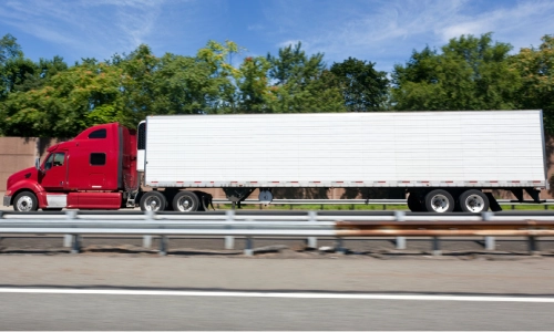 ਤੇਜ਼ੀ ਨਾਲ ਚੱਲਦੀ ਲਾਲ ਮਾਲ ਵਾਹਕ ਟਰੱਕ