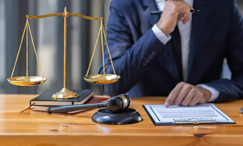 A California personal injury lawyer reads through a legal document attached to a clipboard while sitting in a law office