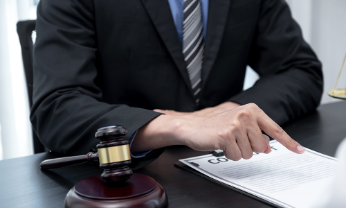 A California personal injury lawyer points at a contract while discussing the details to a client