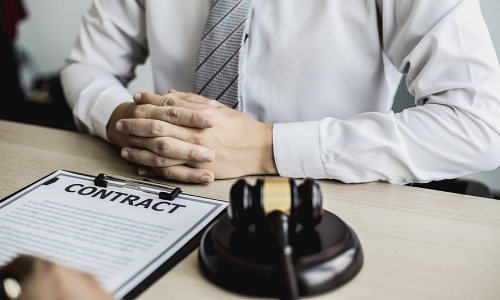 A California slip and fall lawyer sits at an office desk with a legal contract laid on top