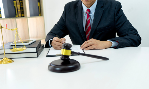 A California hit and run accident lawyer is signing legal documents placed on an office desk