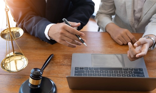 A motorcycle accident lawyer going over case files on a laptop with a colleague