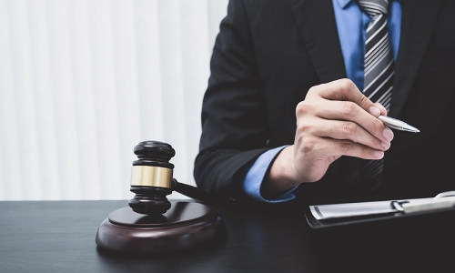 A motorcycle accident lawyer signing a contract and sitting at an office desk