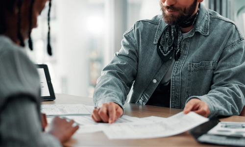 A Texas workers' compensation lawyer showing a document to a client in his office.