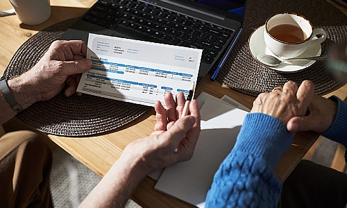 A wrongful death lawyer showing a document to a client with a cup of coffee beside them.