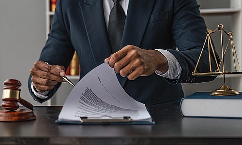 A car accident lawyer going through papers on a clipboard behind his desk.