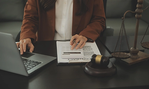 A product liability lawyer updating a file on his laptop.